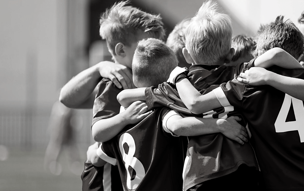 Equipo de fútbol de niños abrazándose
