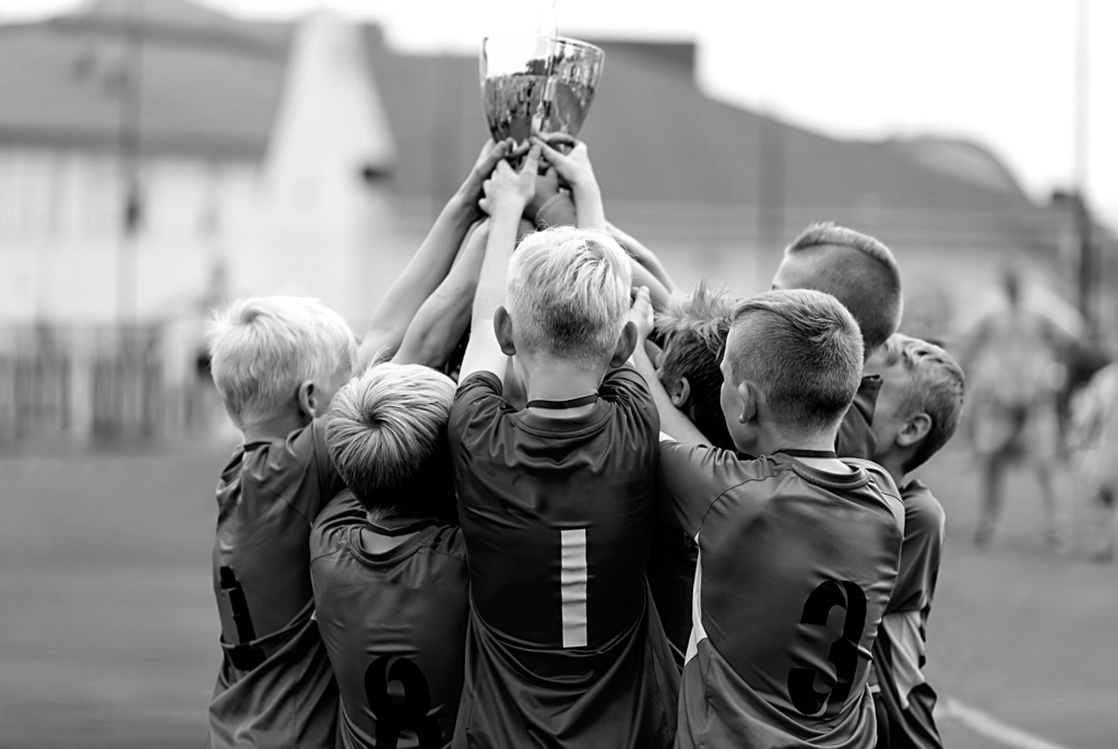 Grupo de niños sujetando una copa durante un torneo de fútbol