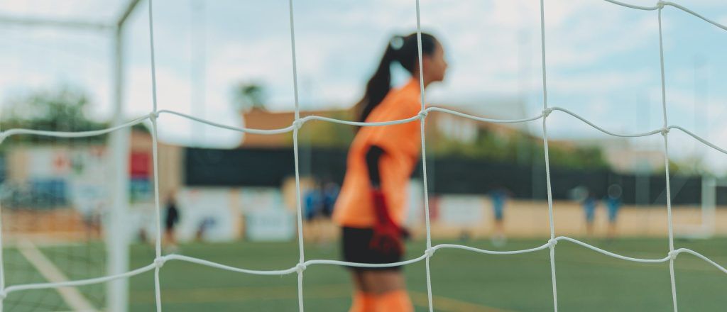 Niña futbolista en una portería de fútbol